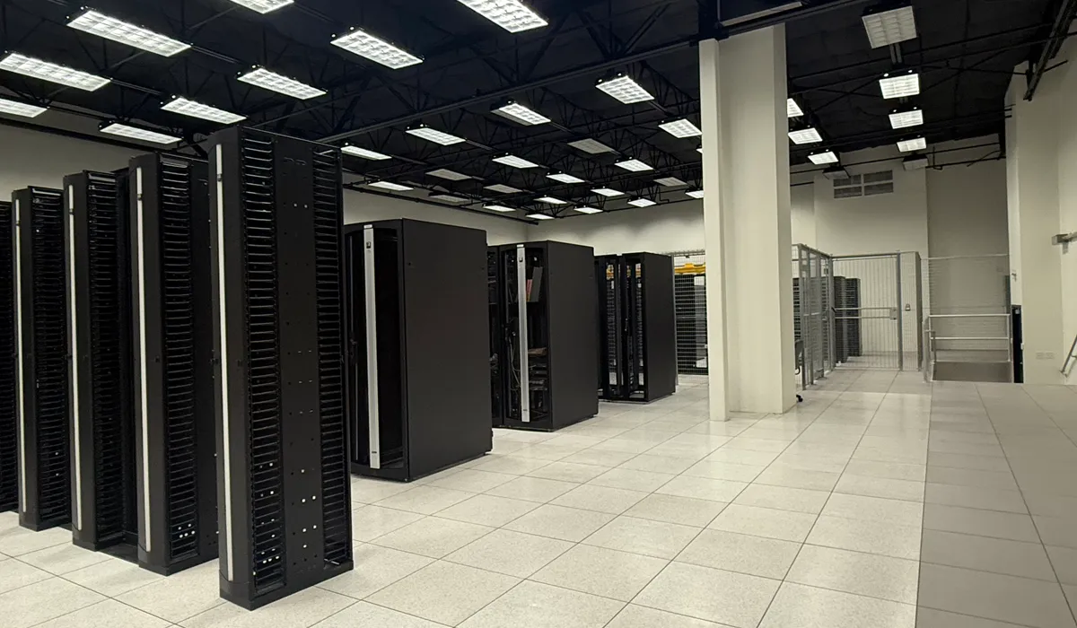 Server cabinets and secure cages on a raised floor inside an Areté Solutions data center